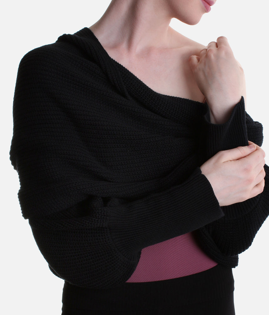 Black Mirella Adagio warm-up scarf worn as a cropped bolero, showing long sleeves and a twisted drape over a plum leotard.