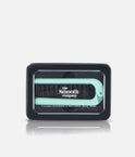 The Smooth Company Foldable Smoothing Travel Brush in mint, shown folded inside its black storage tin.